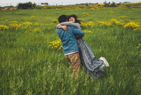 Personas abrazandose en un campo de margaritas